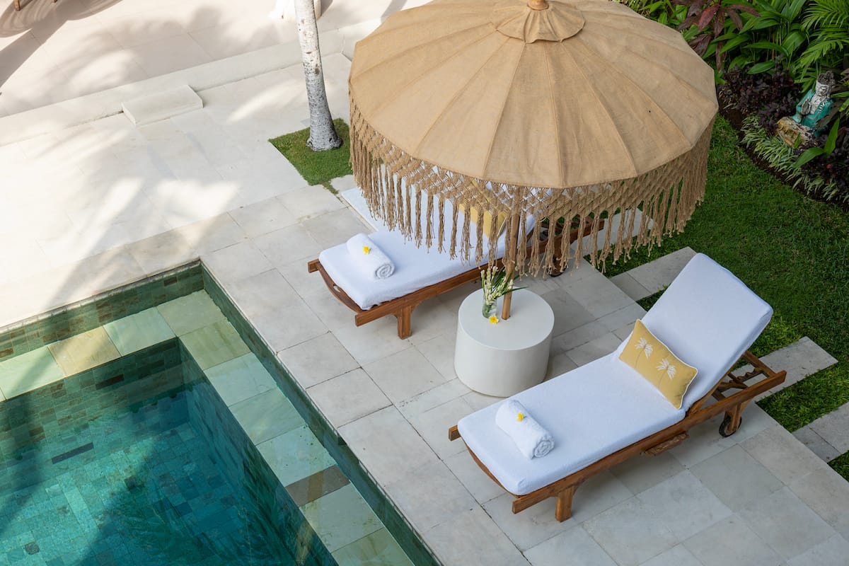 Balcony view of goddess retreats sun Lounge Umbrealla and pool