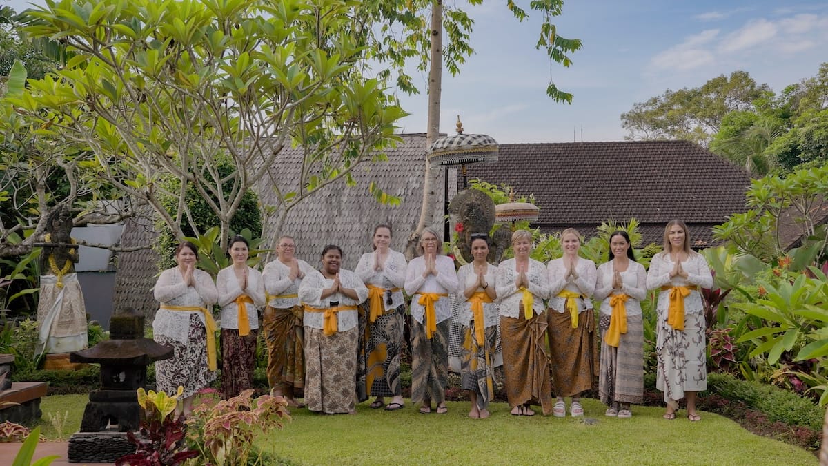 Guest receiving a temple blessing at Ubud Temple, experiencing the spiritual purification ritual at Tirta Empul during a Bali retreat.