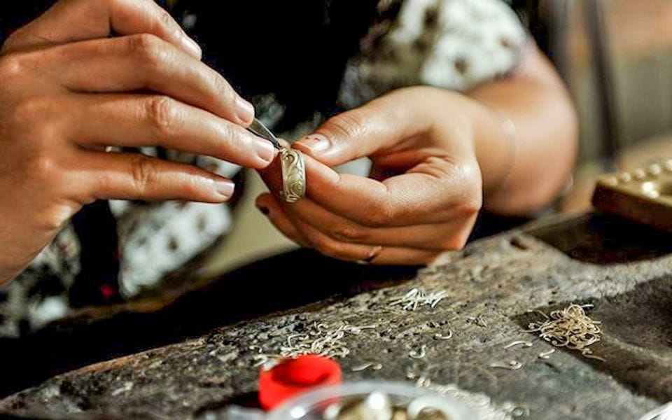 Hands crafting silver jewelry in a traditional silver-making class in Bali, showcasing intricate artisan techniques