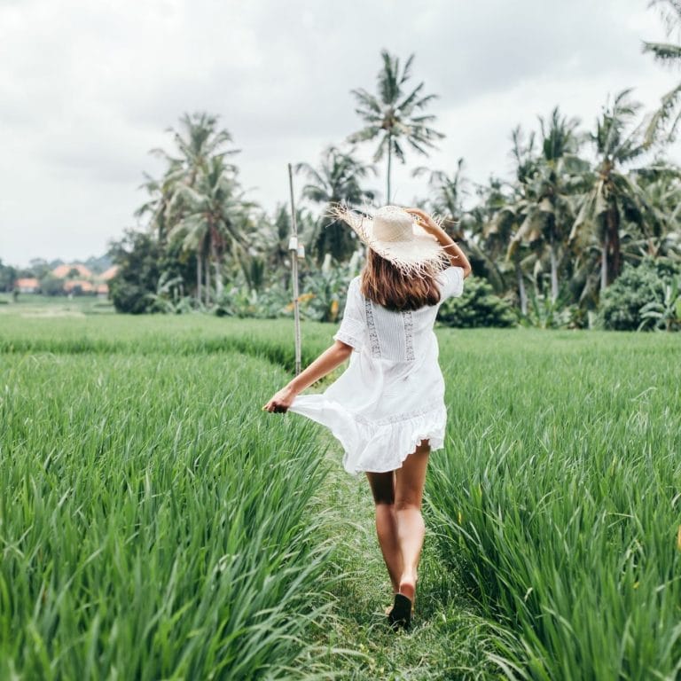 Ubud Bali Goddess Retreats for women walking in Rice paddy white dress