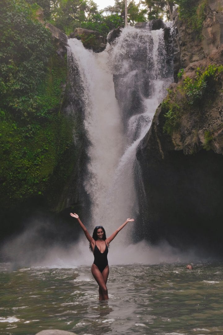 Serene waterfall in Bali surrounded by lush tropical greenery – a peaceful escape at Goddess Retreats