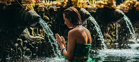 Woman doing melukat in tirta empul Bali